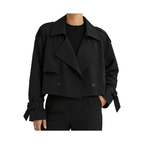 Modelo con gabardina corta cruzada negra de corte oversize, sobre fondo blanco