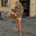 Modelo en la calle con la chaqueta efecto ante en tono topo y bolso marrón