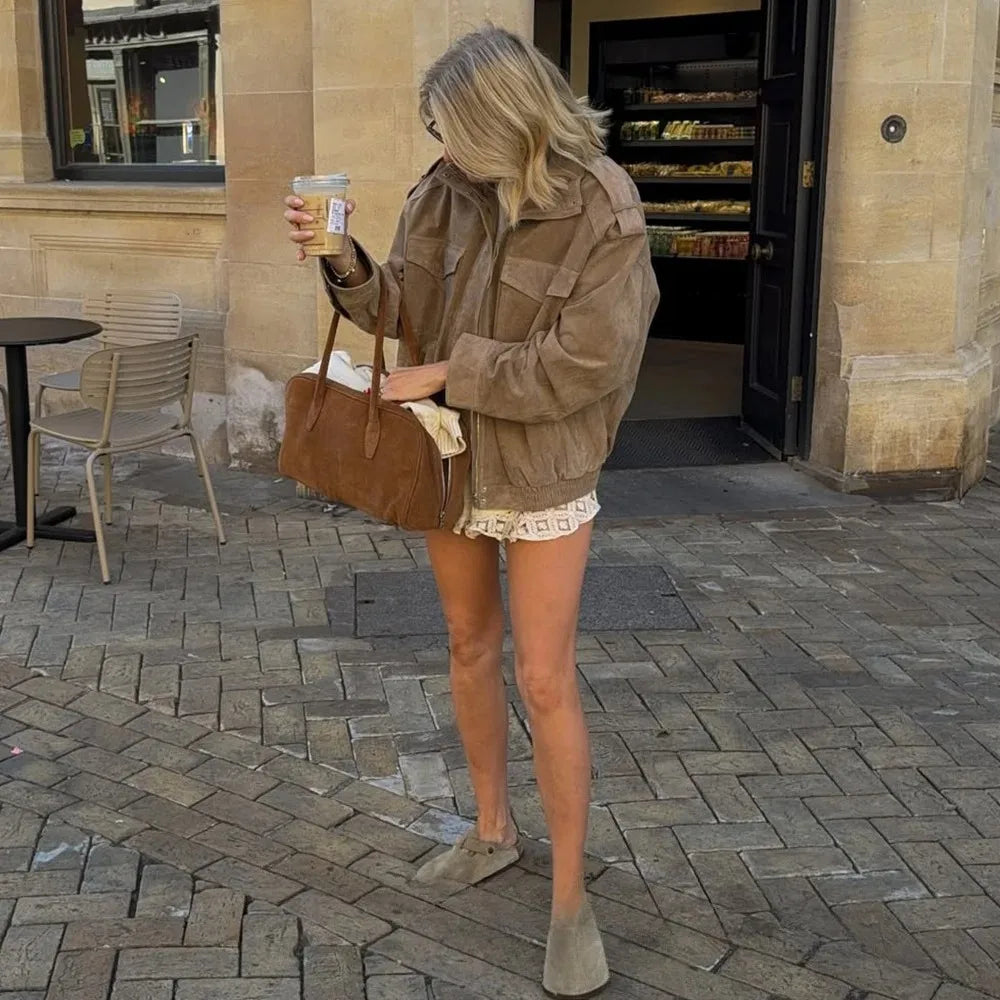 Modelo en la calle con la chaqueta efecto ante en tono topo y bolso marrón