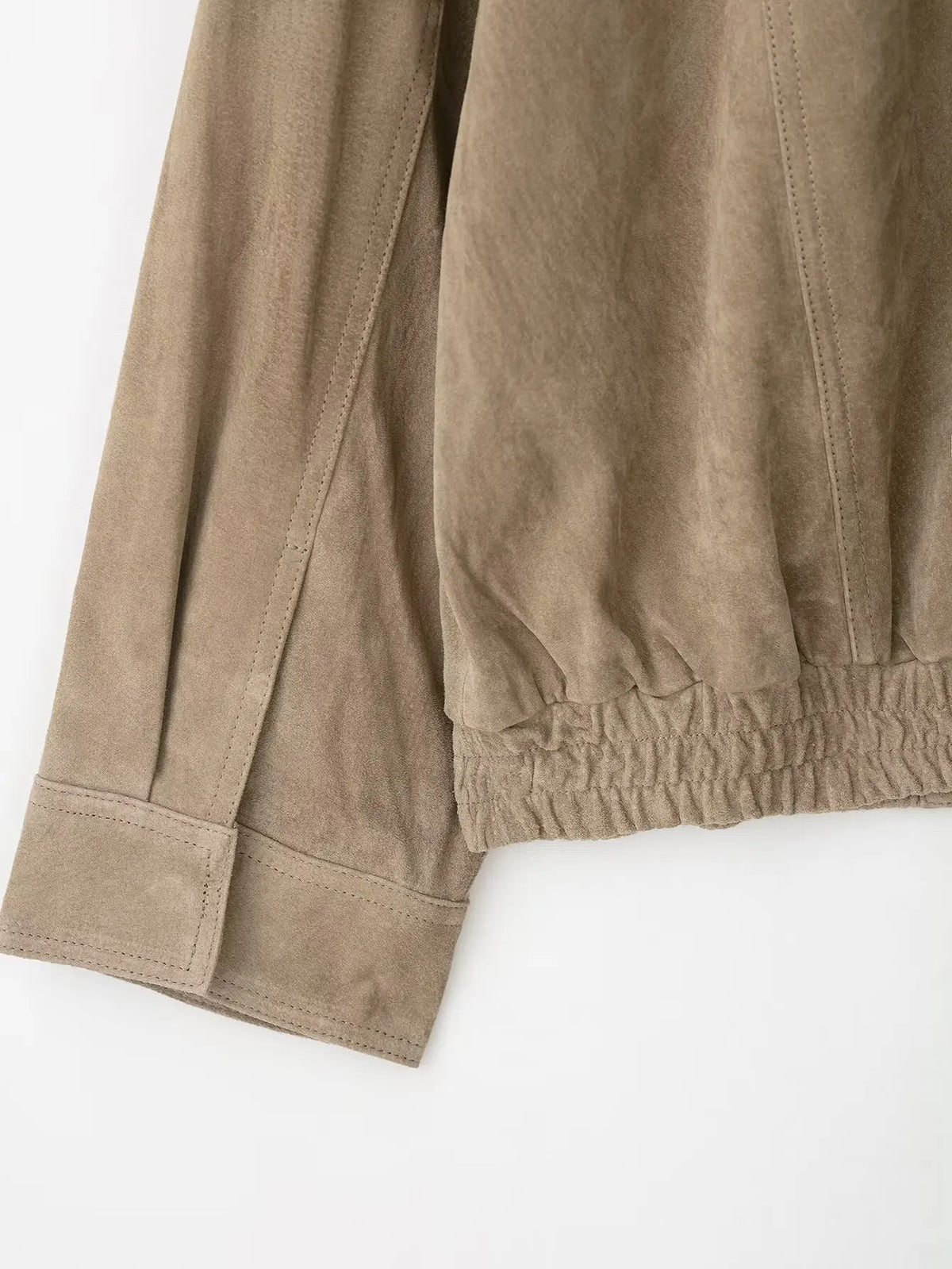 Detalle del puño y del bajo de canalé de la chaqueta en tono topo
