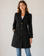 Modelo con gabardina entallada negra de botones, vista frontal