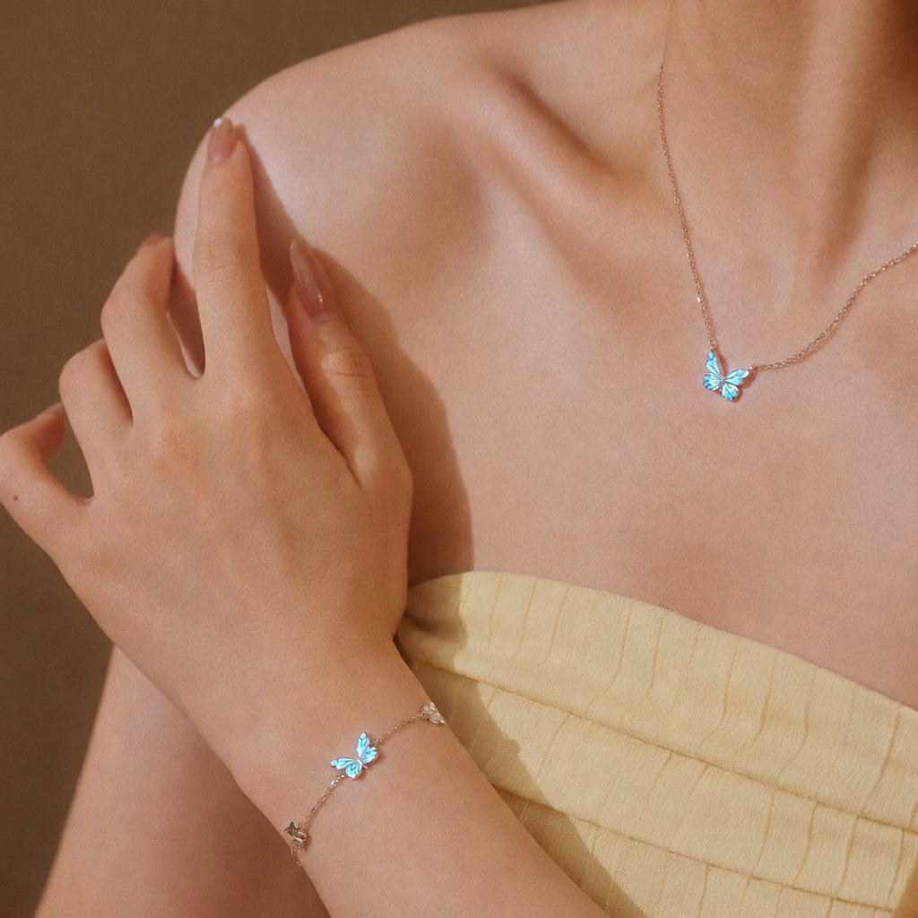 Modelo luciendo el collar y la pulsera del Set Mariposa Azul, con mariposas de esmalte azul en plata de ley
