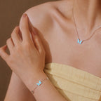 Modelo luciendo el collar y la pulsera del Set Mariposa Azul, con mariposas de esmalte azul en plata de ley